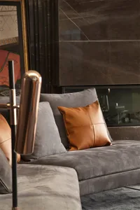 Modern living room featuring a leather couch against a marble wall