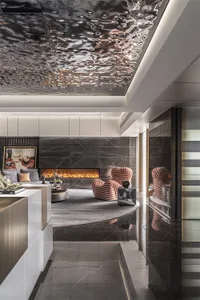 Modern living room with metallic tiles, marble fireplace, and striped armchairs.