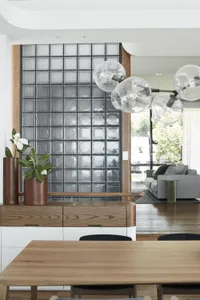 Modern living room with wood furniture, glass wall, and metal accents.