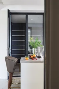 Modern minimalist kitchen with glass cabinets, featuring a sleek design and contemporary style.