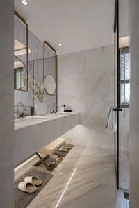 Modern minimalist bathroom with marble walls and flooring, featuring a double sink vanity and a walk-in shower.