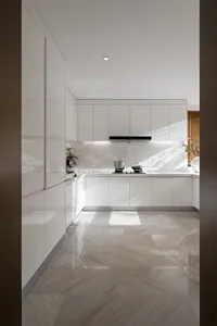 Modern minimalist kitchen with white cabinets, marble countertops, and stainless steel appliances.