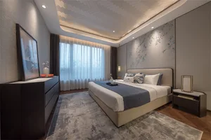 A modern bedroom with textured wallpaper, dark wood furniture, and soft fabrics.