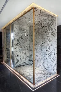 An elegant, minimalist bathroom with marble walls and floor.