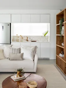 A minimalist living room with a white marble kitchen counter and modern furniture