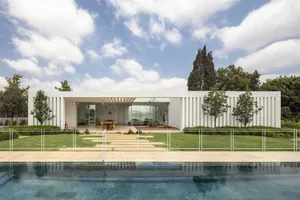 Modern house with glass exterior and large windows.