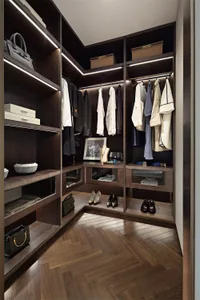 A modern closet featuring dark wood shelving and integrated lighting.