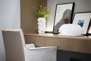 A modern guitar room featuring a wooden shelf with a white vase holding greenery, framed posters of musical instruments, and 
