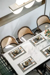 A modern dining room featuring a marble table with place settings.