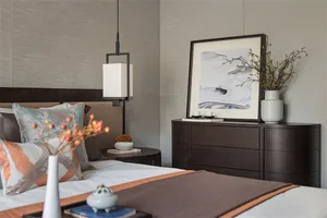 A modern minimalist bedroom showcasing dark wooden furniture, a hanging lamp, a framed painting, and various decorative eleme