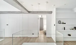 A minimalist open-plan interior with glass dividers and a clean, white color palette.
