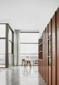 A modern office space with concrete and glass walls and a kitchen area.
