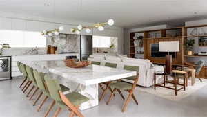 A modern residential interior with a marble dining table and wooden chairs.
