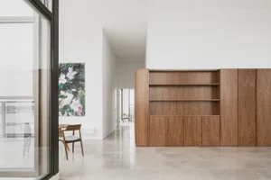 A modern residential living room with wood, glass, and marble features.