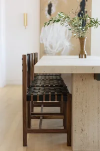 A minimalist interior design featuring wood and leather furniture.