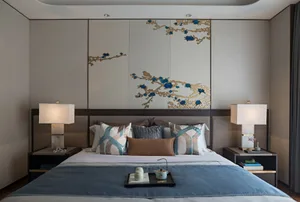 Modern bedroom featuring a bed with mixed white, blue, and brown pillows, a decorative panel with blue and gold floral design
