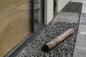 A modern exterior entryway decorated with a decorative stone log.