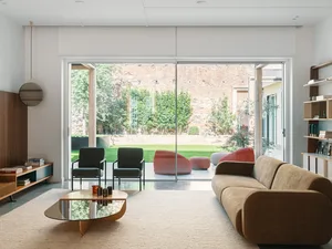 Modern living room featuring a glass window with furniture and a coffee table.