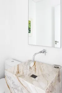 A contemporary white marble bathroom featuring a square sink and a minimalist design.