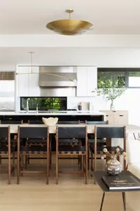 Modern residential kitchen featuring wood, leather, and stainless steel materials