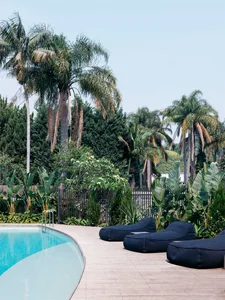 Modern poolside deck featuring wooden flooring and concrete elements.