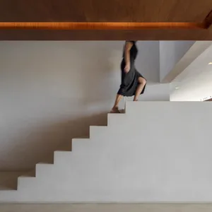 A modern, minimalist staircase made of concrete with a wooden ceiling.