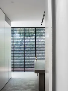 Contemporary office space featuring metal frame windows with closed blinds.