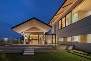 A modern residential house featuring concrete, glass, and wood materials.