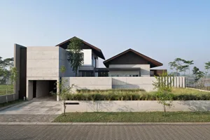 A modern residential home with a concrete exterior and a garage entrance.
