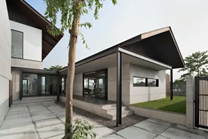 Modern house with concrete exterior and black metal roof.