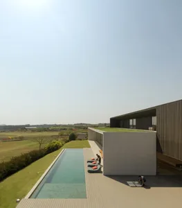 A modern house exterior featuring concrete and glass materials.