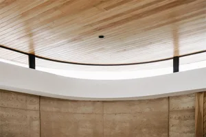 A modern interior with a wooden ceiling featuring sleek, minimalist design elements.