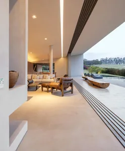A modern living room with concrete flooring and minimalist furniture.