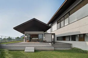 Modern residential house exterior with concrete and glass materials.