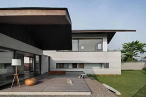 Modern residential exterior featuring a combination of concrete and glass materials.