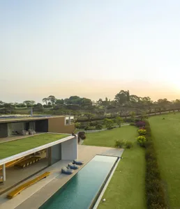 Modern residential exterior featuring wood, glass, and stainless steel.