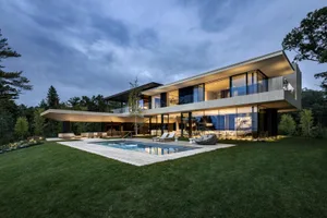 Modern house with extensive use of glass and a backyard pool.