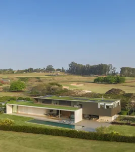 Modern residential home featuring steel and glass structure with a green rooftop.