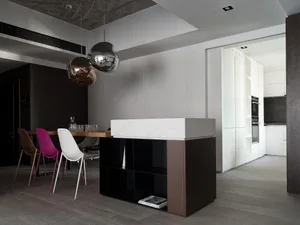 A modern dining and kitchen space featuring marble countertops and concrete finishes.