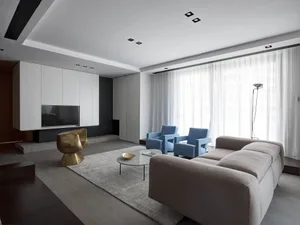 A modern living room with minimalist furniture and neutral-toned decor.