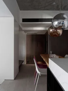 Modern dining area with industrial design elements, featuring wooden dining table, metal chairs, and marble accents.