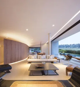 Modern living room with concrete flooring, wood accents, and minimalistic furniture.