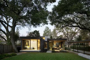 A modern house with a concrete exterior and large glass windows.