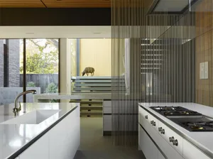 A modern kitchen featuring glass and stainless steel materials and a minimalist design.