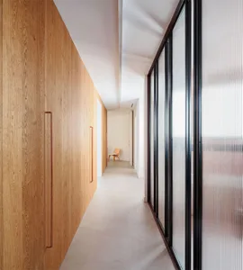 Modern corridor featuring wood, concrete, and glass materials