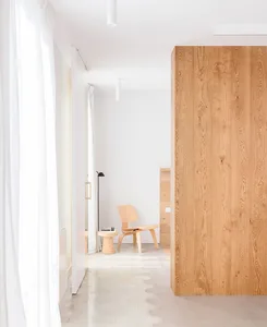 Minimalist white room with wooden floor and furniture, floor lamp, and white curtains, showcasing contemporary design aesthet