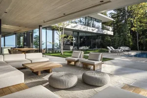 Modern residential patio with wood, glass, and stone materials.