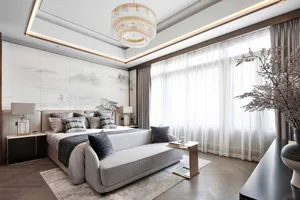 Modern minimalist bedroom featuring gray furniture, white bedding, and abstract art on the wall.