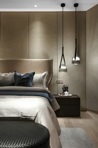 A modern bedroom with fabric bedding and glass pendant lights.