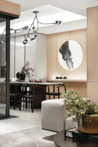 A modern dining room with wooden paneling, featuring a table set for dinner and a large abstract painting on the wall.